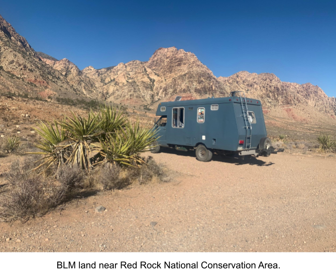 Blue RV Parked Next To Mountains Under Blue Skies